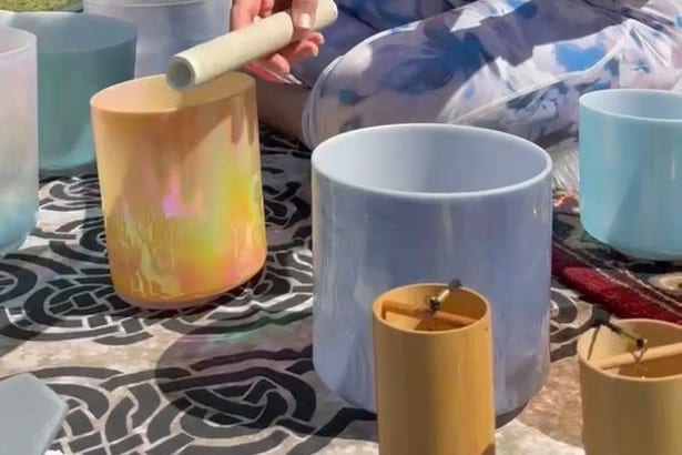 Crystal singing bowls being played on a patterned rug
