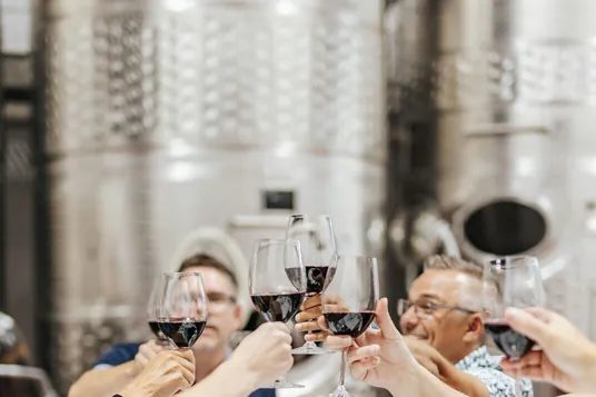 Guests raising glasses at a winery harvest dinner