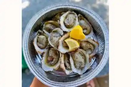 A pan of roasted oysters with lemon at the Keswick Vineyards Fall Oyster Roast